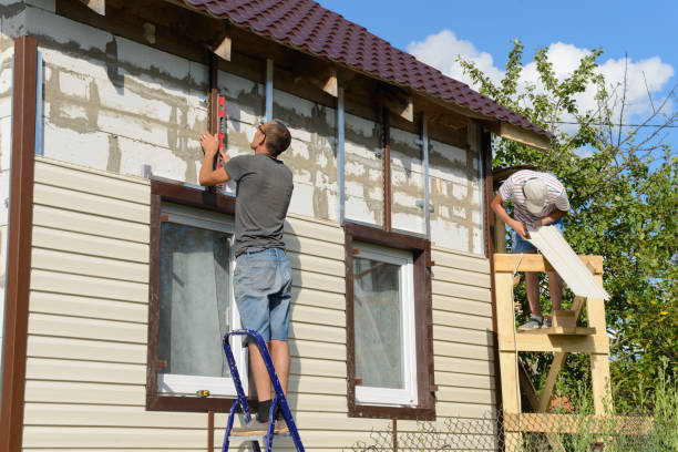 Two workers installing siding on a home under construction
