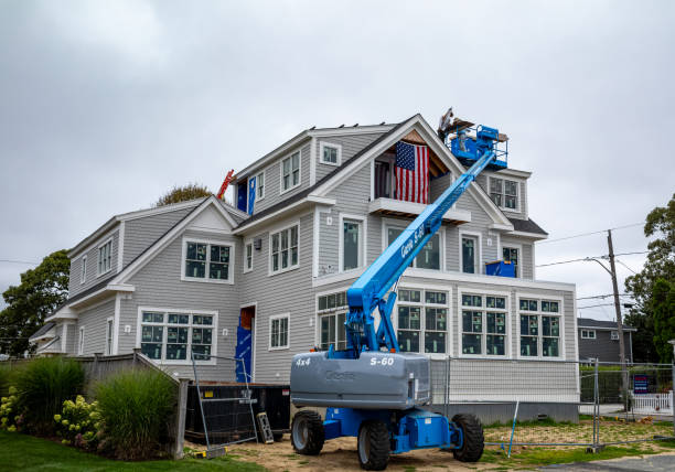Workers using boom lift for siding on new home build