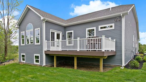 Home featuring installed siding and a spacious backyard deck