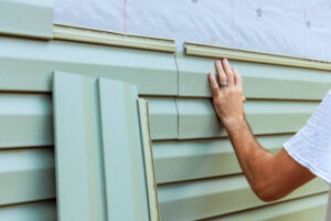 Installing residential vinyl siding panels during home renovation