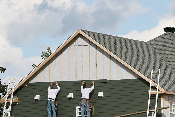 Workers installing vinyl siding on a new home's exterior wall