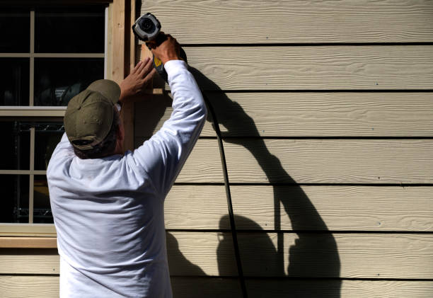 Worker installing James Hardie fiber cement siding around window